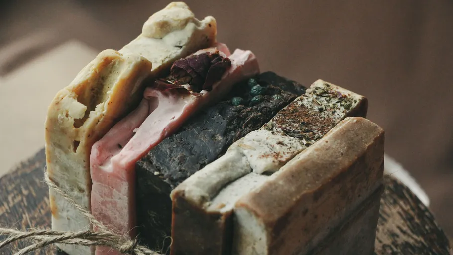 Handmade soap bars stacked with herbs.