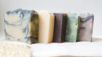 Bunte Seifenstücke stehen auf Handtuch.