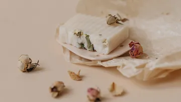 Seife mit getrockneten Blumen auf Papier.