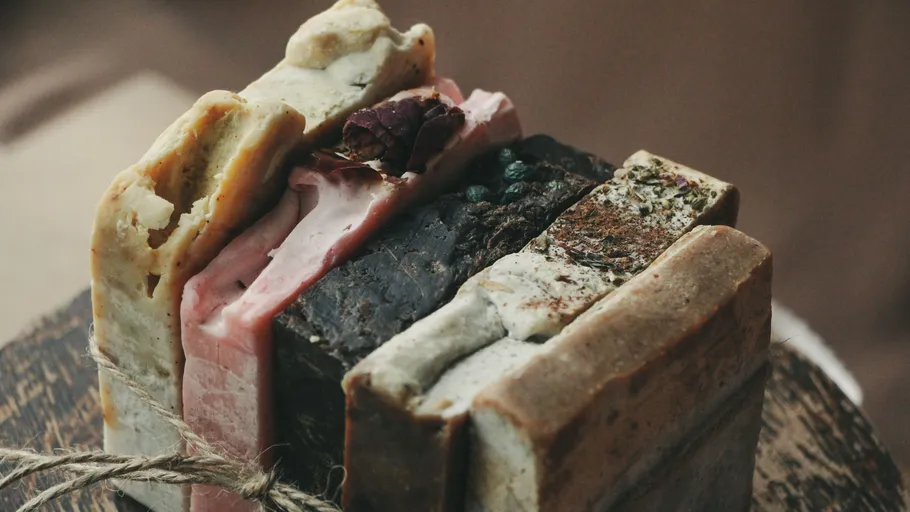 Stacked soaps on wooden surface tied with twine.