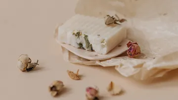 Seifenstück mit getrockneten Blumen auf Papier.