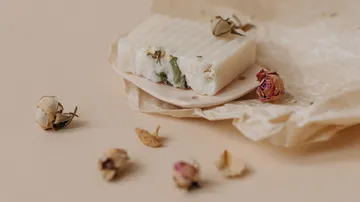 Natürliche Seife mit Trockenblumen auf Papier.