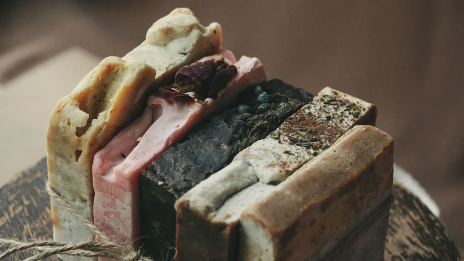 Stacked handmade soap bars on wooden surface.