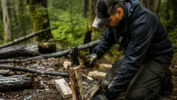 Man chopping wood in forest area.
