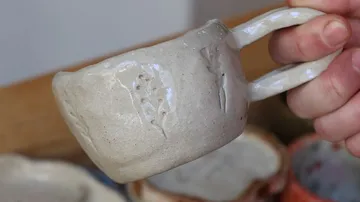 Keramiktasse von Hand gehalten, drinnen.