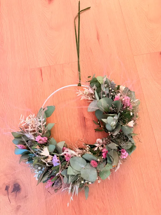 Blumenkranz auf einem Holzboden liegend.