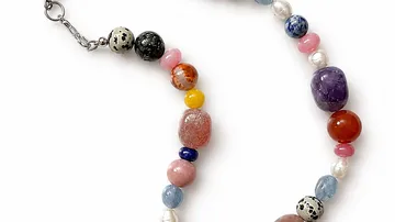 Buntes Armband mit verschiedenen Perlen auf weißem Hintergrund.