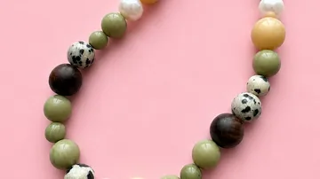 Colorful beaded necklace on pink background.