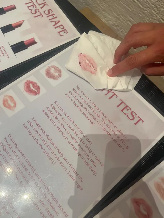 Hand holding napkin with lipstick kiss.