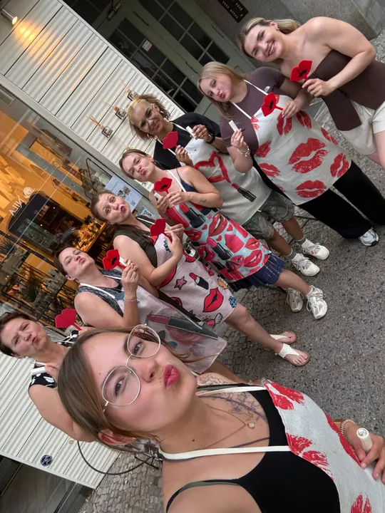 Group posing outside with kiss-themed props.