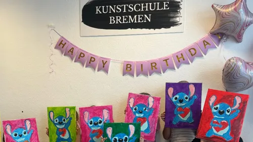 Children holding paintings of cartoon characters indoors.