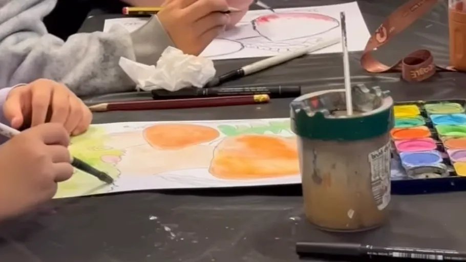 People painting at a table with watercolors.