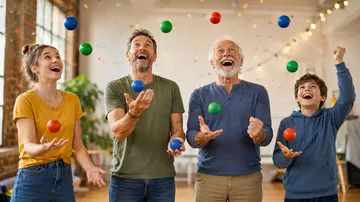 Four people juggling balls indoors