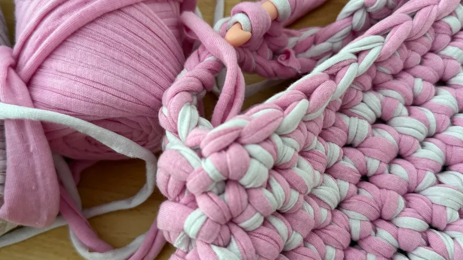 Pink crochet yarn and half-finished project.