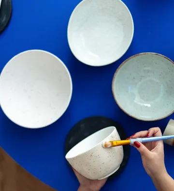 Hand bemalt Schüssel auf blauem Tisch.