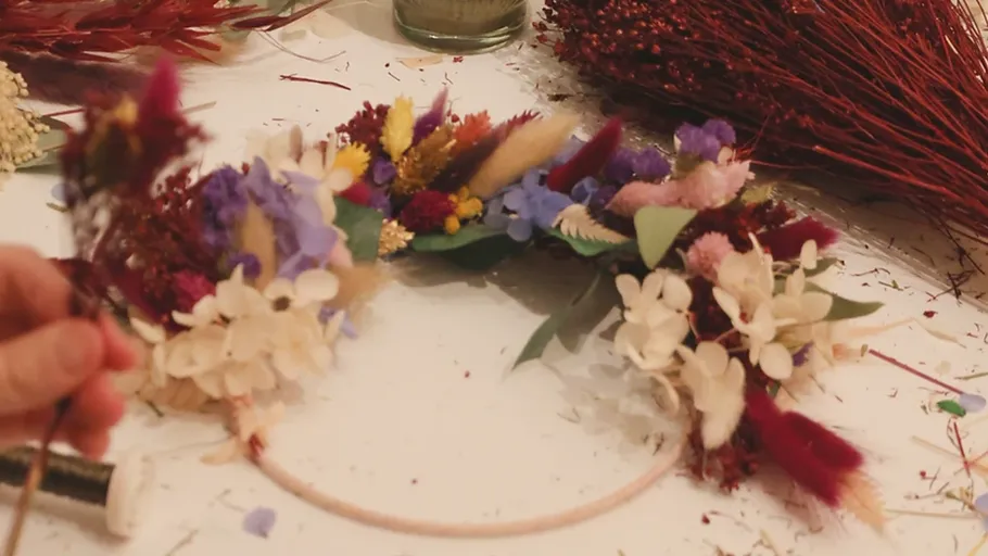 Wreath with colorful dried flowers on table.