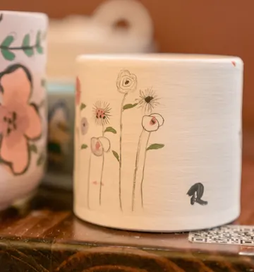 Verzierter Becher mit Blumendesigns im Innenbereich.