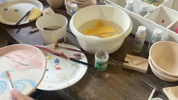Hand bemalt Keramikteller auf Holztisch.