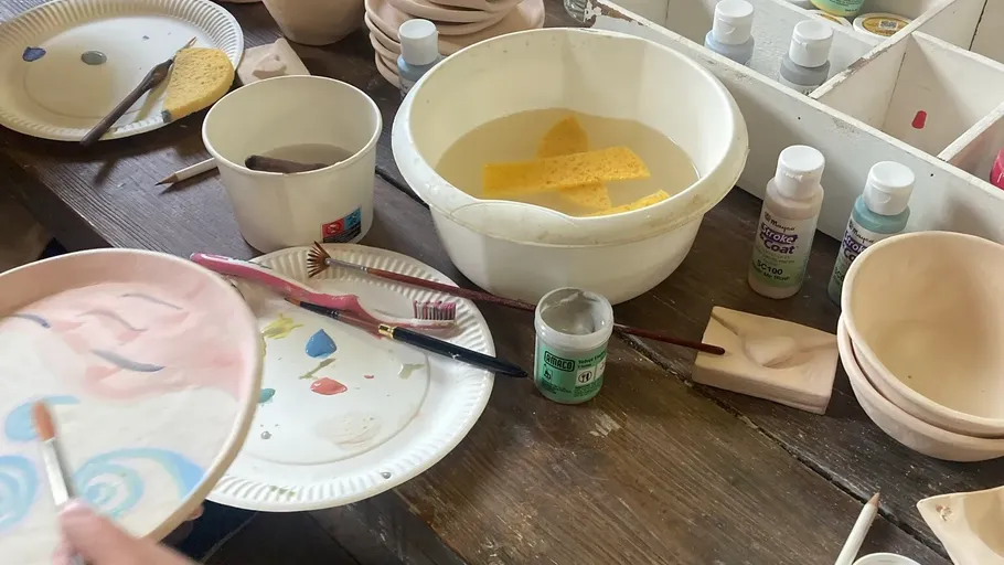 Hand painting ceramic plate on wooden table.