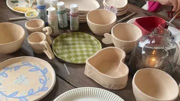 Ceramic bowls and paints on a table.
