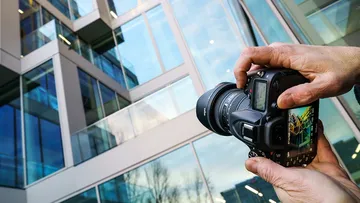 Kamera fotografiert modernes Glasgebäude-Außenseite.