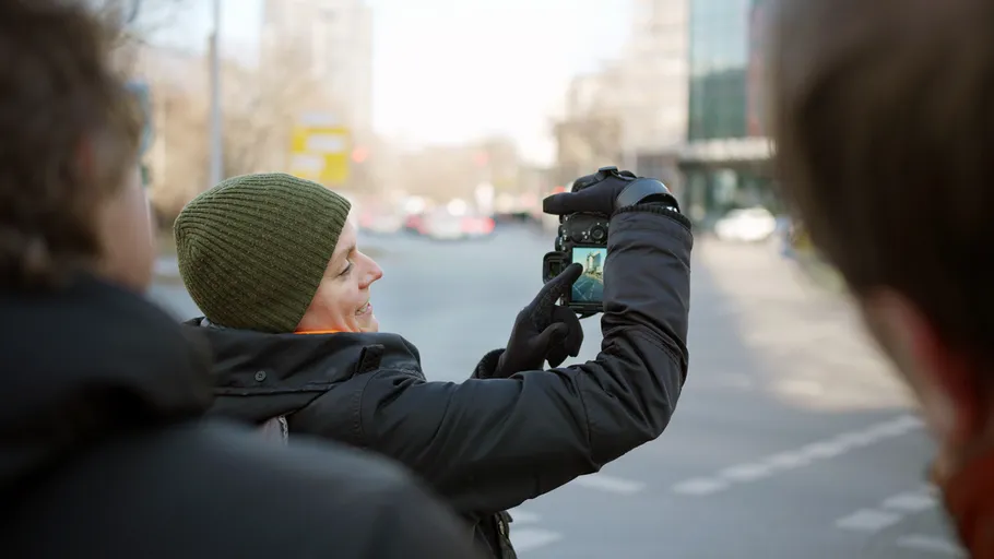 Person taking photo on city street.