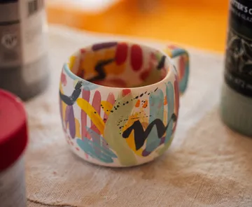 Colorful mug with abstract patterns on table.