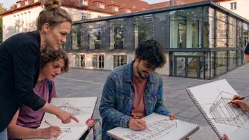 Students sketching buildings outside a university.