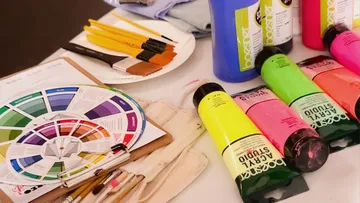 Kunstzubehör mit Farben, Pinseln, Farbkreis.