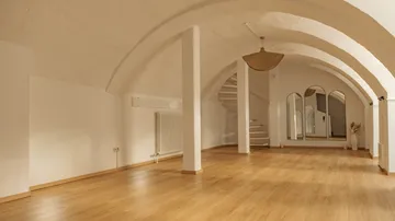 Empty room with arched ceiling, wooden floor.