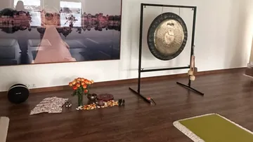 Gong im Yogastudio mit Dekorationen drumherum.