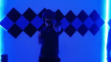 Person mit VR-Headset in blau beleuchtetem Raum.