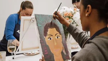 Person malt Porträt im Kunstkurs.
