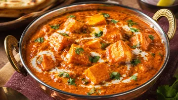 Paneer-Curry serviert in verzierter Schüssel.