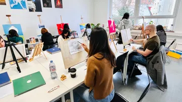 People painting at an art studio.