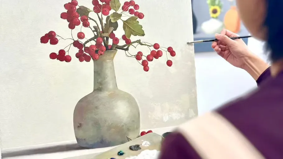 Artist painting vase with red berries.