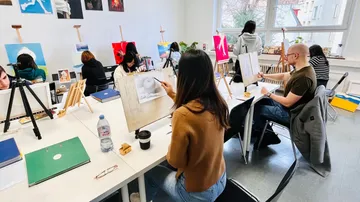 People painting in a bright art studio.