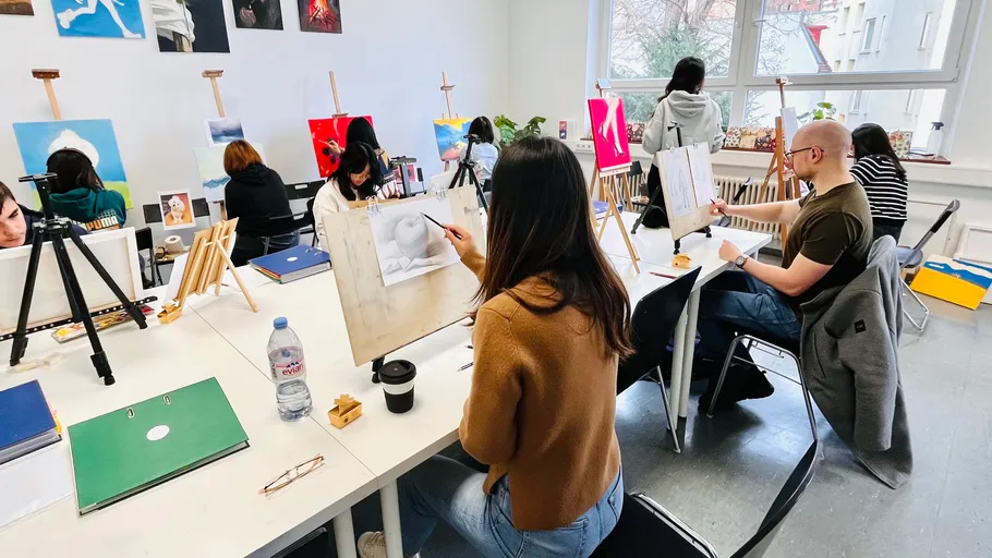 People painting in a bright art studio.
