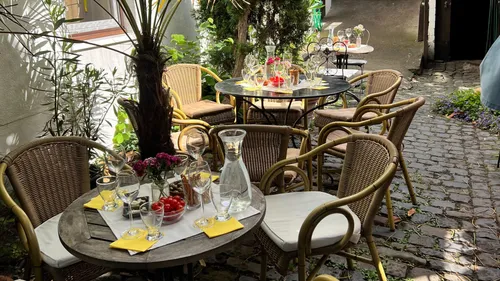 Outdoor tables set for dining in garden.