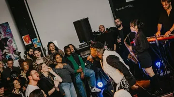 Band performing for cheering audience in club.