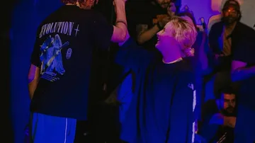 Zwei Personen geben High-Five, Publikum schaut zu.