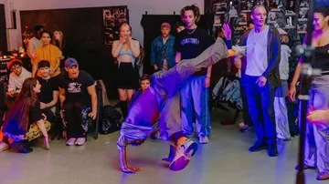 Dancer performs handstand in lively crowd.