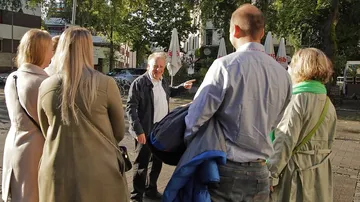 Gruppe von Leuten im Gespräch draußen.