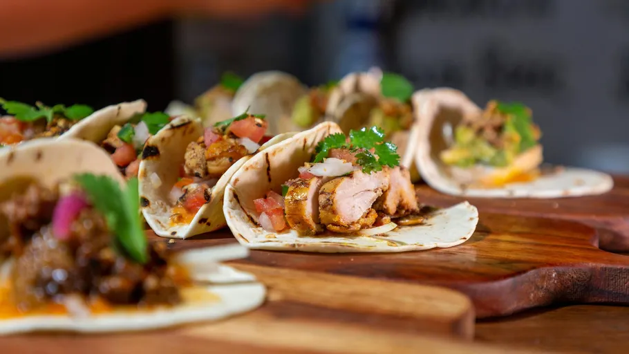 Tacos mit Hühnchen und Gemüse auf einem Brett.