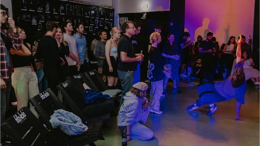 Person breakdancing in crowded indoor space.