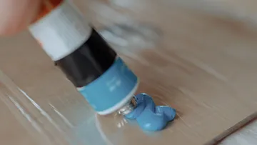 Farbentube drückt blaue Farbe auf Palette.