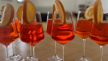 Glasses filled with orange cocktails on table.