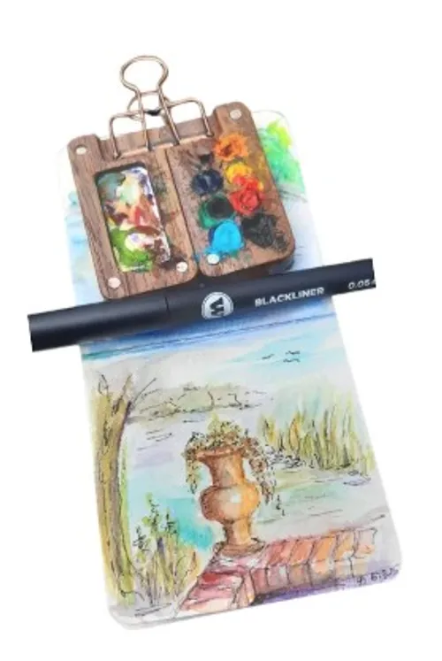 Farbpalette und Stift auf Aquarellskizze.