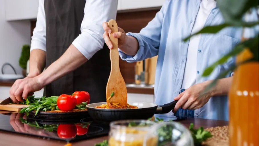 Zwei Personen kochen in einer Küche.