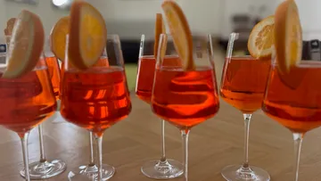 Cocktails mit Orangenscheiben auf einem Tisch.
